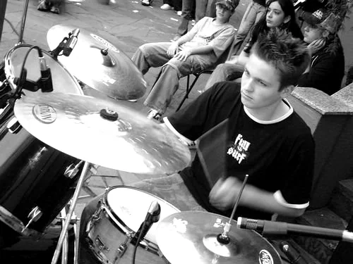 Kevin tocando bateria em apresentação antiga