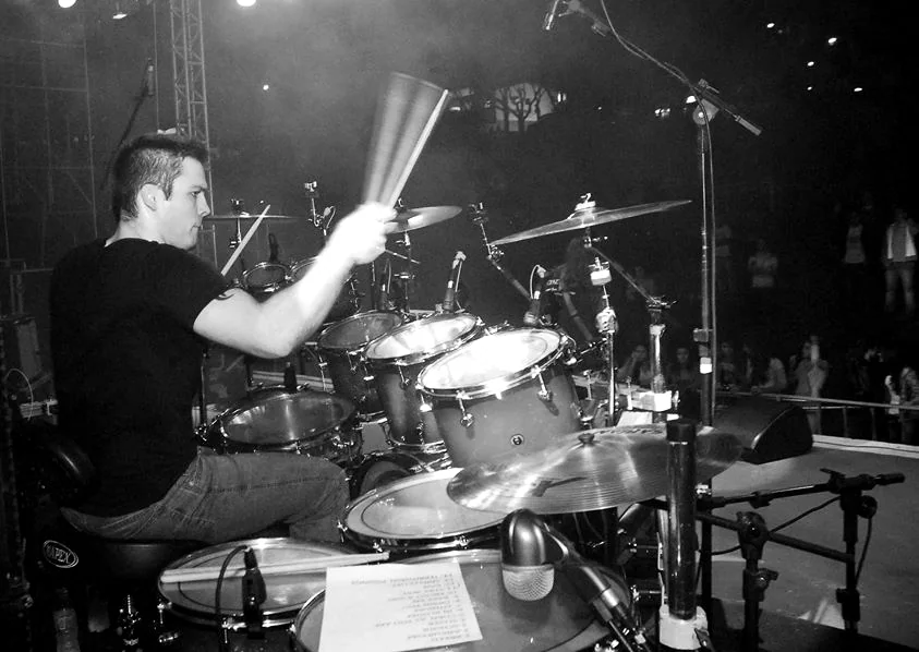 Kevin tocando bateria em um show, registro de arquivo