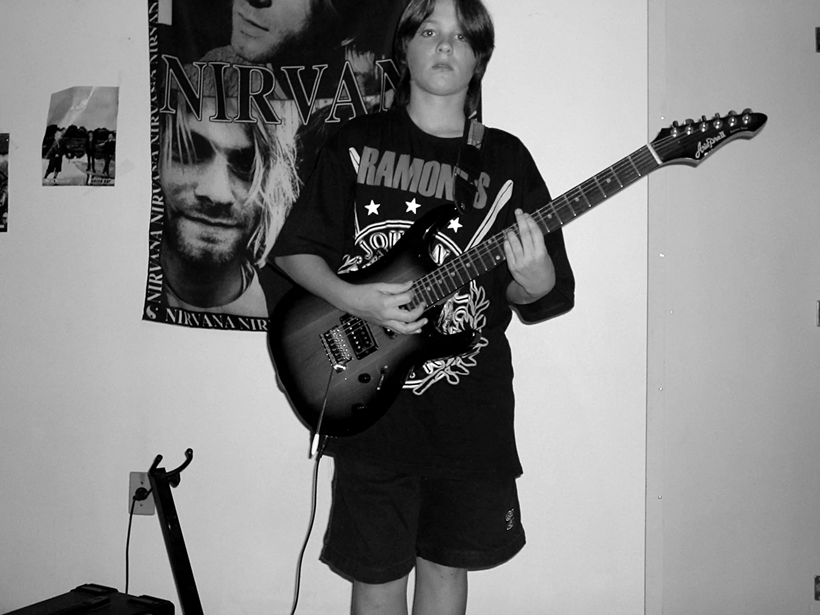 Kevin jovem segurando guitarra, registro de arquivo
