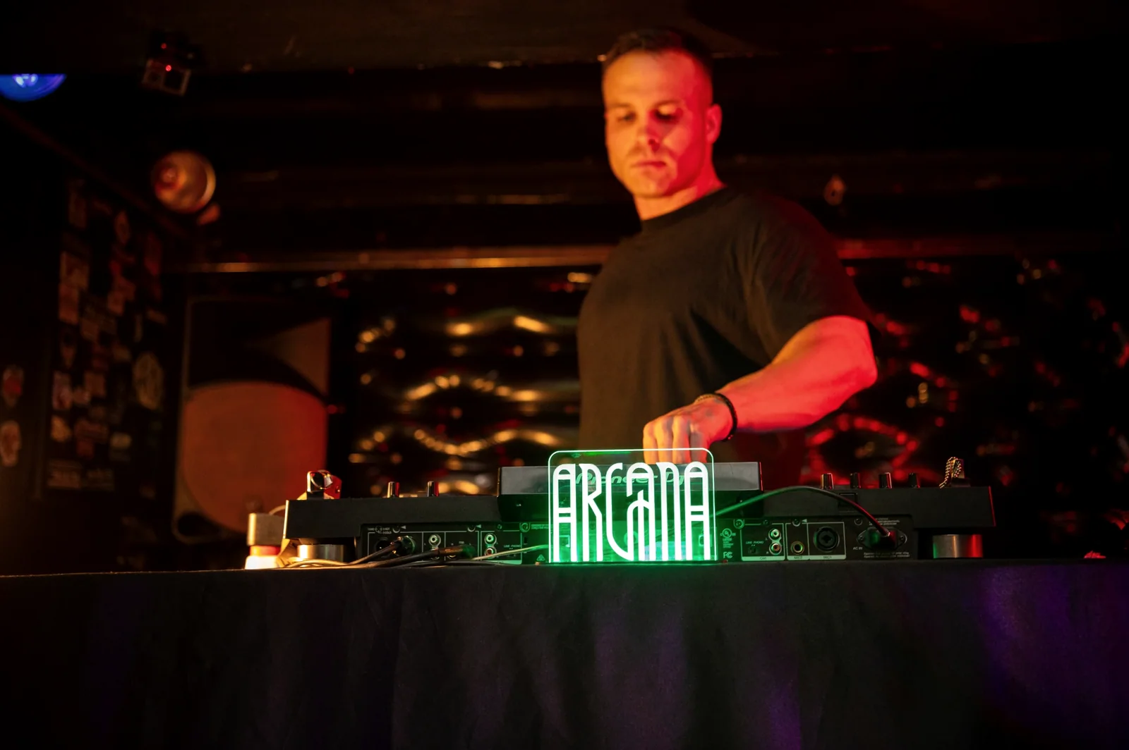 Kevin se apresentando como DJ em ambiente com iluminação quente